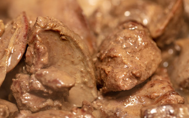 Chicken liver is fried in a pan.