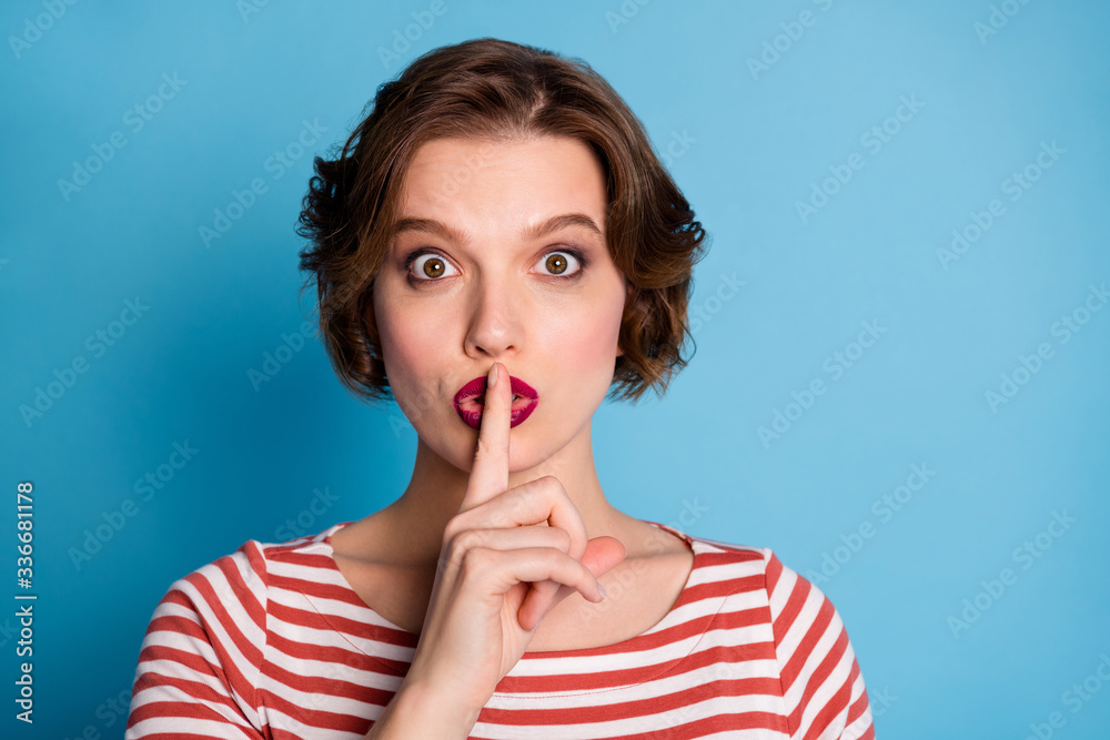 Poster Hush please. Closeup photo of beautiful pretty lady hold index finger on lips asking colleagues keep silence wear casual red white shirt isolated blue color background