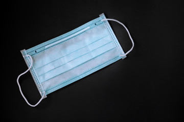 blue medical protective mask isolated on black background. copy space