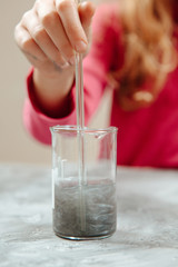 Woman's hand mixing skincare with herbal essence, preparing organic raw materials for beauty products. Handmade beauty treatment.