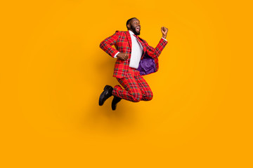 Fototapeta na wymiar Full length profile photo of crazy dark skin guy jump high up celebrate successful achievement wear plaid red costume blazer pants shoes isolated bright yellow color background