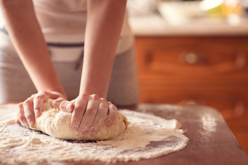 Obraz na płótnie Canvas Female hands making dough for pizza