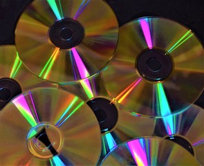 Multiple CDs DVDs discs on pile closeup