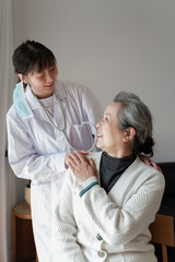 Obraz premium Young family doctor is talking with seniors