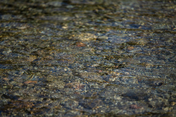 River pebbles under water. Texture. Greenish tint