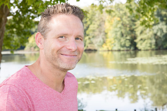 Handsome Blonde Man Smiling On Lake Side Pond Park Nature Background