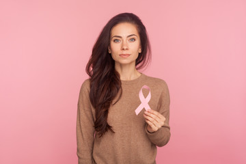 Female health check awareness. Portrait of beautiful young woman with brown hair holding pink...