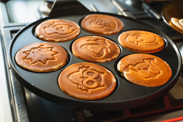 rosy pancakes on a frying pan. The process of cooking food