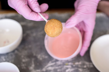 The pastry chef makes dessert on a stick. Cake pops. Chocolate cream for dessert, creation process.
