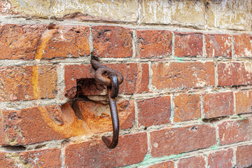 Rusty iron hook in the brickwork of an old gate