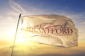 Brantford of Ontario of Canada flag waving on the top sunrise mist fog