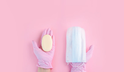 Hands in medical gloves lie on a pink background.