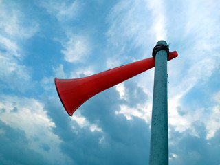 a red plastic horn tie with a white plastic pipe with blue sky background