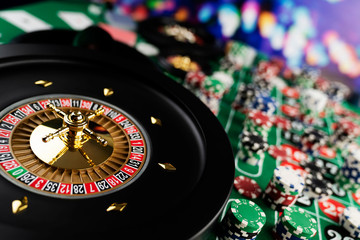 Roulette table in casino. Casino felt green table with red and black numbers. Stack of poker chips.