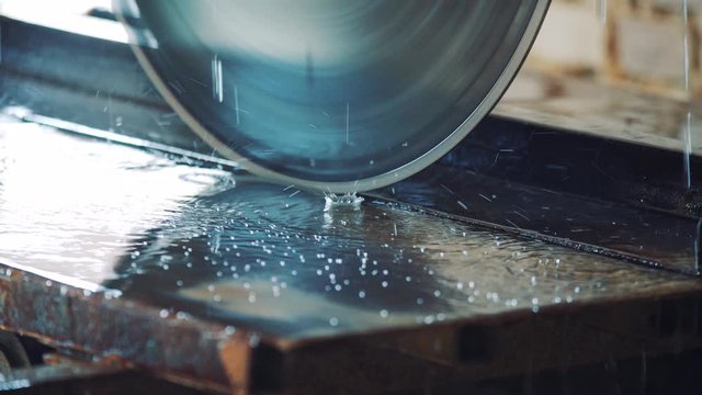 Drops of water falling on the table and on a circular saw for cutting a stone.