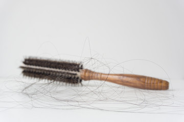 Comb with hair loss on white background.