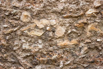 old brown stone wall of dilapidated historic building, background with architectural elements