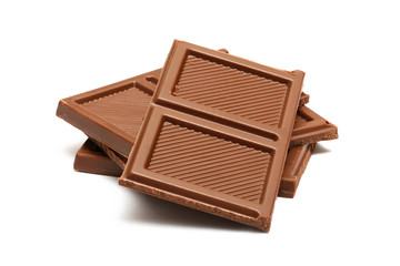 Broken milk chocolate pieces heap isolated on white background