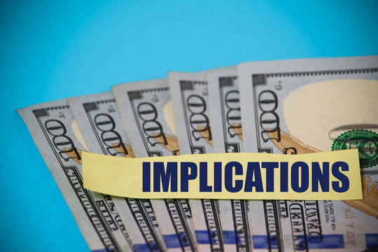 Sticker with the inscription or text: " Implications " on the background of dollars