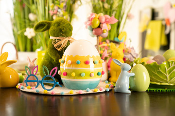 Easter theme. Easter decorations. Easter eggs in basket and easter bunny. Bouquet of spring flowers.