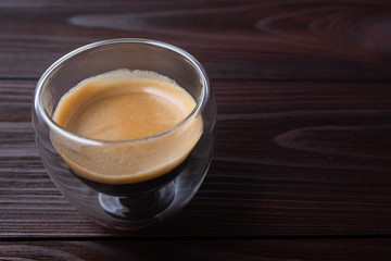 Coffee in a glass cup on wooden background