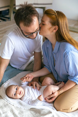 Three-month-old baby in the arms of happy young parents. The most touching moments with father and mother