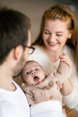 Cute three-month-old girl in her mother’s arms. Essential needs for love and comfort