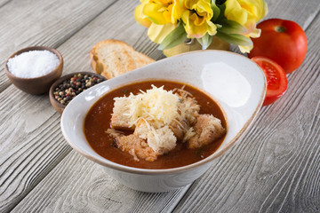 Delicious soup with cheese and meat in a restaurant on a white wooden table