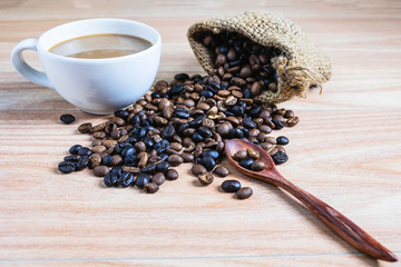 Coffee cups and roasted coffee beans on a wooden table