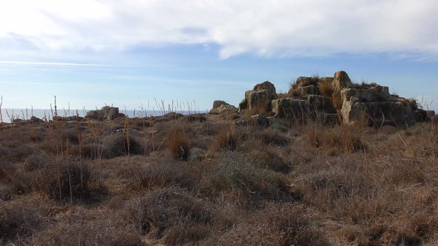 Remains of the walls of the ancient necropolis against the blue sky
