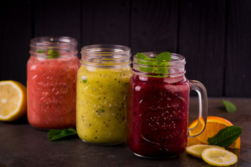  three beautiful glasses jars of fruit smoothies on a red checkered napkin on a wooden tray juicegrated berriesberry drinkpulp juice