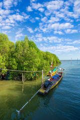 Obraz premium A fisherman brought his small wooden boat to shore during dusk at mangrove swamp forest in Surabaya