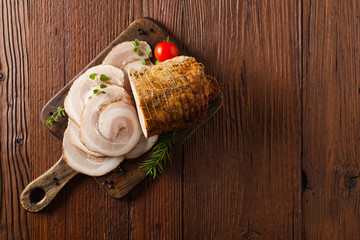 Whole bacon roulade. Served in sliced meat with white sauce. Top view.