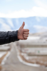 Close up hitchhiker man hand at deserted road