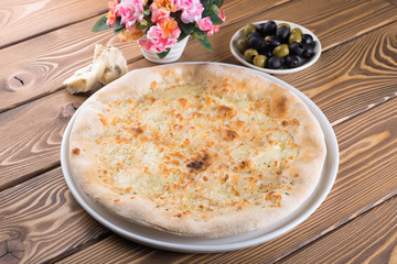 Delicious pizza with cheese, olives and greens