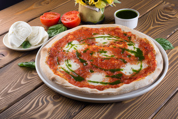 Delicious pizza with cheese, tomatoes, olives and greens