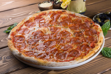 Delicious pizza with cheese, tomatoes, olives and greens