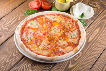 Delicious pizza with cheese, tomatoes, olives and greens