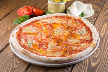 Delicious pizza with cheese, tomatoes, olives and greens