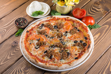 Delicious pizza with cheese, tomatoes, olives and greens