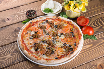 Delicious pizza with cheese, tomatoes, olives and greens
