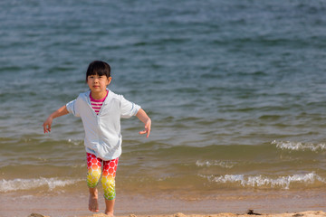 Fototapeta na wymiar 海水浴場で砂遊びをしている可愛い子供