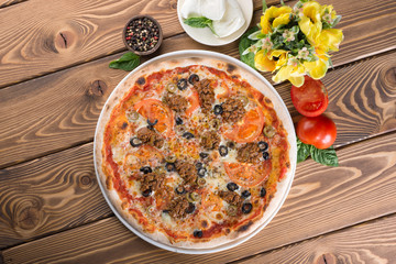Delicious pizza with cheese, tomatoes, olives and greens
