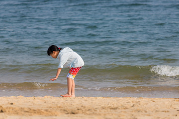 海水浴場で砂遊びをしている可愛い子供