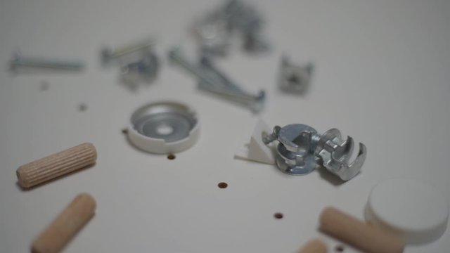 Close up men's hand picks up details for furniture