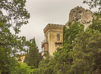 Fototapeta premium Old residential buildings surrounded by green trees on the background of mount Cat in Simeiz.Crimea.
