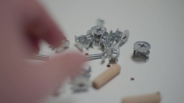 Close up men's hand picks up details for furniture
