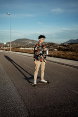 Portrait Guy with style and modern with a longboard in the street