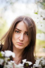 Beautiful girl on   background of flowering trees