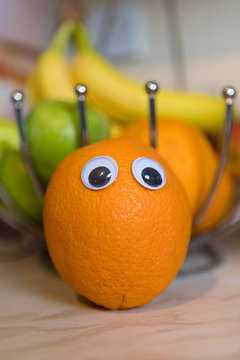 Orange fruit in the fruit bowl with bobbly eyes